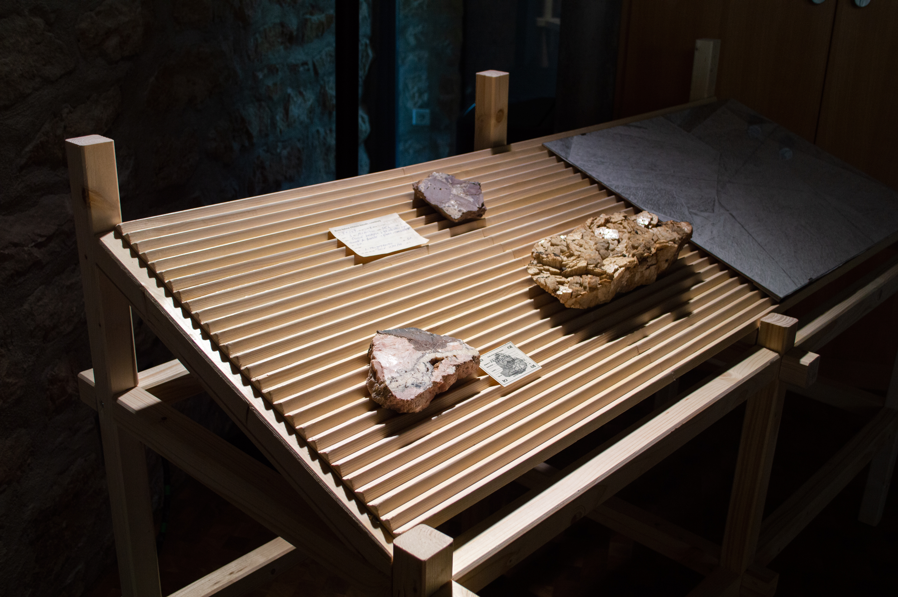 Fantômes de roches - Rock Ghosts, Installation composed of an edition, drawings, glass engravings, slide projections & wooden modules (spruce) with samples from the geological collections of the RBINS, (Module design/scenography: Kieran Young), 2022. With the support of WBI and ISELP